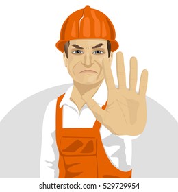 mature road worker in hard hat showing stop gesture