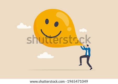 Maximize happiness, let go anxiety and think positive concept, man blow big smile yellow balloon.