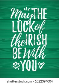 May The Luck Of The Irish Be With You handdrawn dry brush style lettering on green wooden background, 17 March St. Patrick's Day celebration. Suitable for greeting card design, poster, etc., vector il