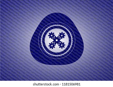 mechanism icon inside badge with denim background