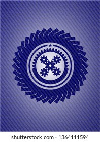 mechanism icon inside badge with denim texture