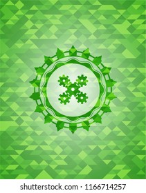 mechanism icon inside green emblem with mosaic ecological style background