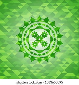 mechanism icon inside green emblem with mosaic background