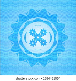 mechanism icon inside light blue water wave badge.