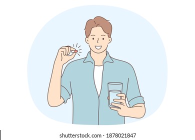 Medical drugs and vitamin concept. Young smiling man cartoon character standing and holding glass of water and pill capsule painkiller or vitamin medication in hands before taking in 
