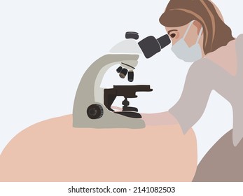 Un trabajador médico examina un microscopio.