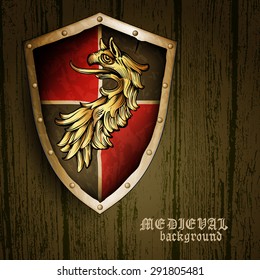 medieval heraldic shield with a griffin on a wooden background