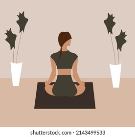 meditating girl practicing candlelight yoga in a room with two large flowerpots