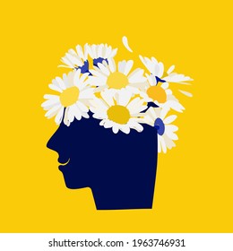 Mental health concept. Abstract image of a head with flowers inside. Chamomile, flowers and leaves as a symbol of inspiration, calmness, favorable mental behavior. 