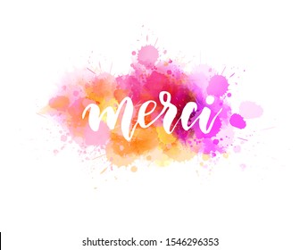 Merci - Thank you in French language. Handwritten modern calligraphy lettering text on multicolored watercolor paint splash background.