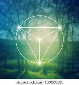 Merkaba sacred geometry spiritual new age futuristic illustration with interlocking circles, triangles and glowing particles in front of blurry natural photographic background