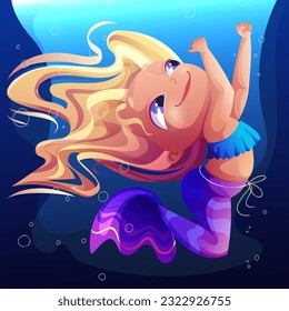 A mermaid in a blue tank top and purple fin costume with yellow blond hair swims underwater
