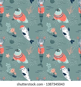 Mermaid in jacquard pullover Walrus in sweater Seal in Santa hat Seaweed Coral Starfish decorative Xmas repeatable print. Underwater Christmas seamless vector pattern. Seasonal holidays wrapping paper