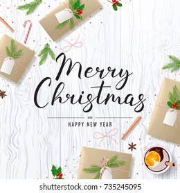 Merry Christmas Background with Festive Decoration. Beautiful Greeting Card with Lettering. Top View on Composition with Paper Gift Boxes for Happy New Year. Vector Illustration.