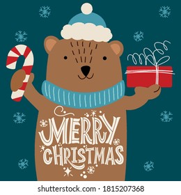 Merry Christmas. Bear in a hat with a gift and an inscription on the belly. Great lettering for greeting cards, stickers, banners, prints and home interior decor. Xmas card. Happy new year 2021.