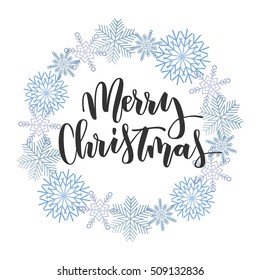 Merry Christmas black hand written inscription with blue snowflakes wreath on white background