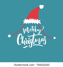 Merry Christmas caption in red Santa hat at blue background. Funny card design