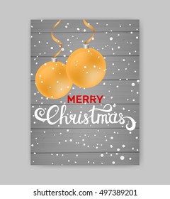 Merry Christmas card with golden balls on gray wooden background. Christmas hand written caligraphy
