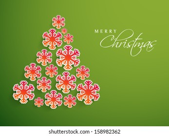 Merry Christmas celebration concept with Xmas tree made by beautiful snowflakes in pink color on green background, can be use as flyer, banner or poster. 