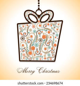 Merry Christmas celebration with floral decorated gift box hanging on shiny background.