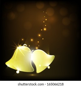Merry Christmas celebration greeting card or invitation card with shiny golden jingle bells on shiny brown background. 