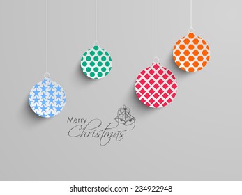 Merry Christmas celebration with stylish and colorful X-mas balls hanging on grey background.