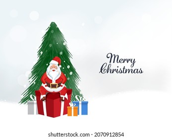 Merry Christmas Concept With Fir Tree Behind Cute Santa Claus Sitting On Gift Box And White Bokeh Background.