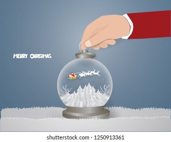 Merry Christmas concept,Hand Santa Claus Picked .Santa Claus on the sky with sled and deer in Snow globe,paper craft style and illustration