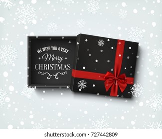 Merry Christmas design. Opened black empty gift box with red ribbon and bow isolated on winter  background with snow and snowflakes. Template for, banner, brochure or poster. Vector illustration.