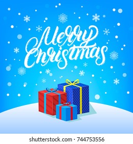 Merry Christmas hand written lettering design with falling snow, snowflakes and gifts. Modern brush calligraphy Christmas card. Blue background. Vector illustration.