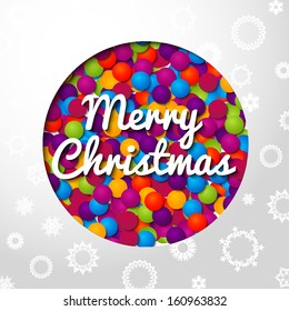 Merry Christmas handwritten swirl lettering on greeting card made from bundle of bright confetti on paper with snowflakes, and cut through paper in shape of christmas ball. With place for your text