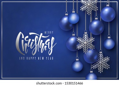 Feliz Navidad y Feliz Año Nuevo, las letras con bolas 3D azules realistas de Navidad y los decorativos copos de nieve de plata cuelgan de las cadenas de oro en un fondo rojo