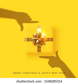 Merry Christmas and Happy New Year. Yellow background with realistic festive gifts box. Effect of the shadow of hands is holding a gift in focus. Photo Frame Hands Made by Young Girls. Xmas present