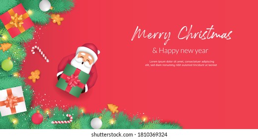 Merry Christmas and Happy New Year. Christmas tree branches decorated with candies, gift boxes and bumble balls.  There is Santa holding a gift box and decorated in red background.