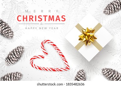 Merry christmas and happy new year. Christmas background. Festive bright design composition top view. Gift box with gold bow decoration, fir cones, candy canes forming a heart. Vector illustration