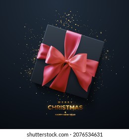 Merry Christmas and Happy New Year golden sign. Black gift box with pink bow and crossing ribbons on black background. Vector holiday 3d illustration. Square box with gold confetti particles. Top view