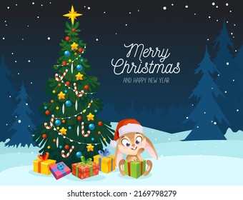Merry Christmas and Happy New Year greetings card. Cute rabbit character in a hat under the ornamented Christmas tree with gifts. The rabbit is a symbol of the year 2023 in the Chinese calendar.