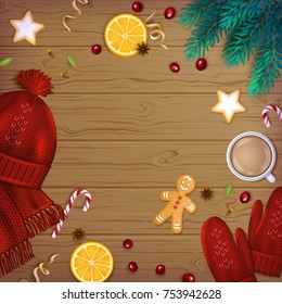 Merry Christmas and Happy New Year Greeting Background. Winter Elements fir branches, knitted red hat, mittens, cup of coffee, spice, sweets, garland, berries, ribbons on a wooden table. Top View.