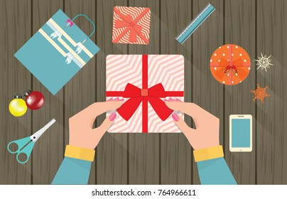 Merry Christmas and Happy New Year, Female hand tied ribbon box with a gift on Wooden board, top view  of christmas holiday handmade present in paper with red ribbon, vector illustration.