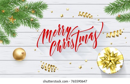 Merry Christmas holiday golden decoration and calligraphy font for greeting card on white wooden background. Vector Christmas or New Year golden shiny gift ribbon for Xmas decoration design