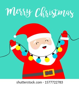 Merry Christmas. Santa Claus holding lightbulb glowing garland fairy lights. Xmas decoration. Cute cartoon kawaii funny baby character smiling face. New Year. Greeting card. Blue background. Vector