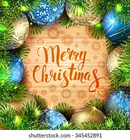 Merry Christmas. Template vector card. Calligraphy. Lettering. Fir tree with golden and blue balls on the wood table. Shiny garland. 