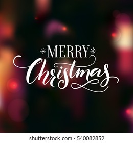 Merry Christmas Text. Calligraphy With Swashes On Dark Night Background With Lights And Bokeh Effect