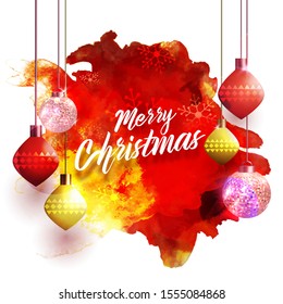 Merry Christmas text with hanging shiny baubles and disco balls on red and yellow watercolor splash background.