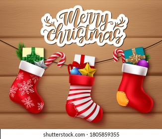 Merry christmas vector banner design. Merry christmas greeting text with hanging santa socks and xmas decoration element for holiday celebration. Vector illustration