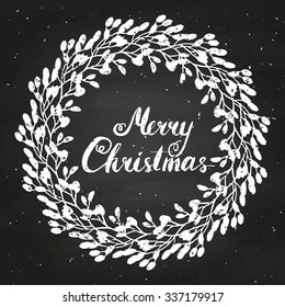 Merry Christmas with vintage wreath with berries and leaves. Hand lettered calligraphic design. Brush typography for poster, t-shirt or cards. Vector illustration on chalkboard.