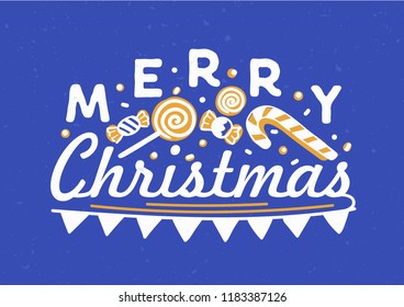 Merry Christmas wish written with elegant cursive calligraphic font. Handwritten holiday lettering decorated with flag garland, candies, lollipops. Colored vector illustration for greeting card.