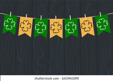 Merry garland of green and yellow little flags with attributes of St. Patrick's Day. Stock Illustration Vector with flags on clothespins against a dark texture wood.Irish style interior decoration.