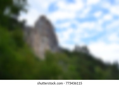 mesh blurred background landscape with a mountain against a blue sky with clouds