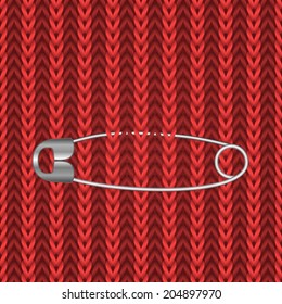 Metal safety pin on the red knitting seamless background.